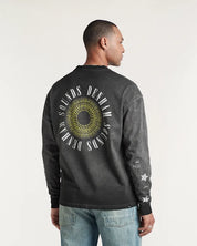 Person wearing a black long-sleeve shirt with a circular design and text on the back, standing against a plain background.