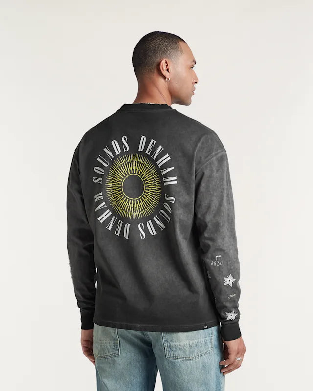 Person wearing a black long-sleeve shirt with a circular design and text on the back, standing against a plain background.
