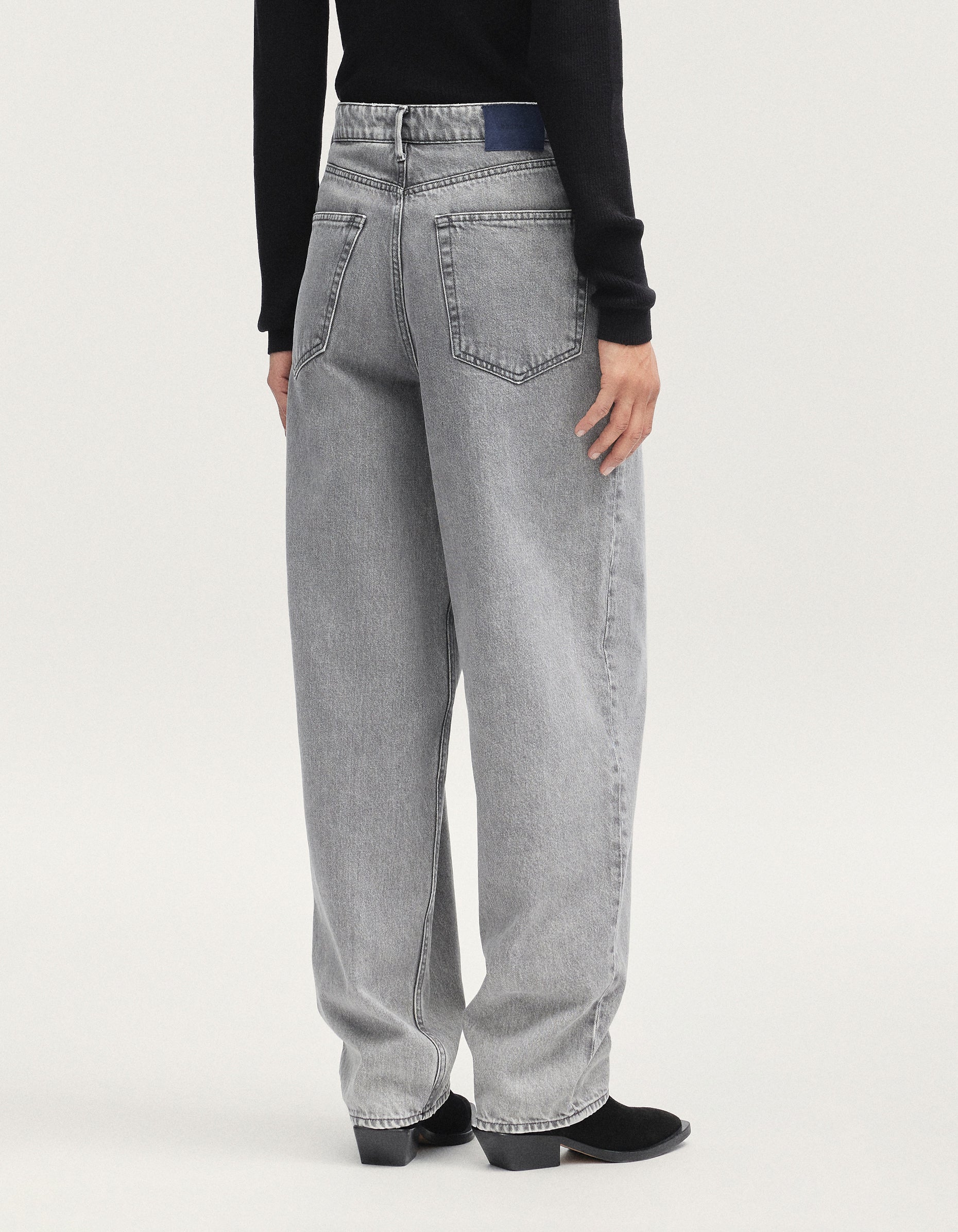Person wearing gray jeans on a white background