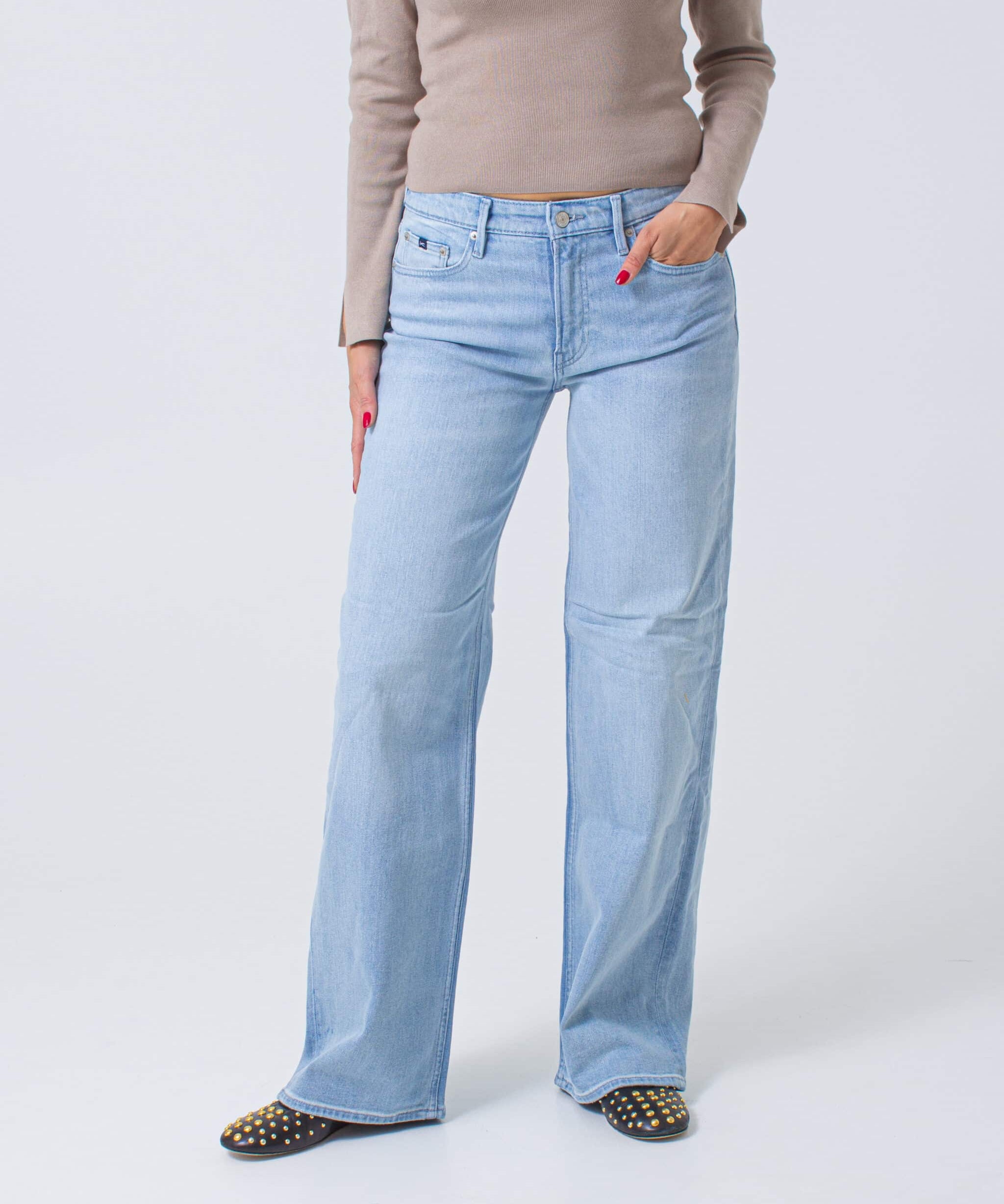 Light blue jeans worn by a person on a white background