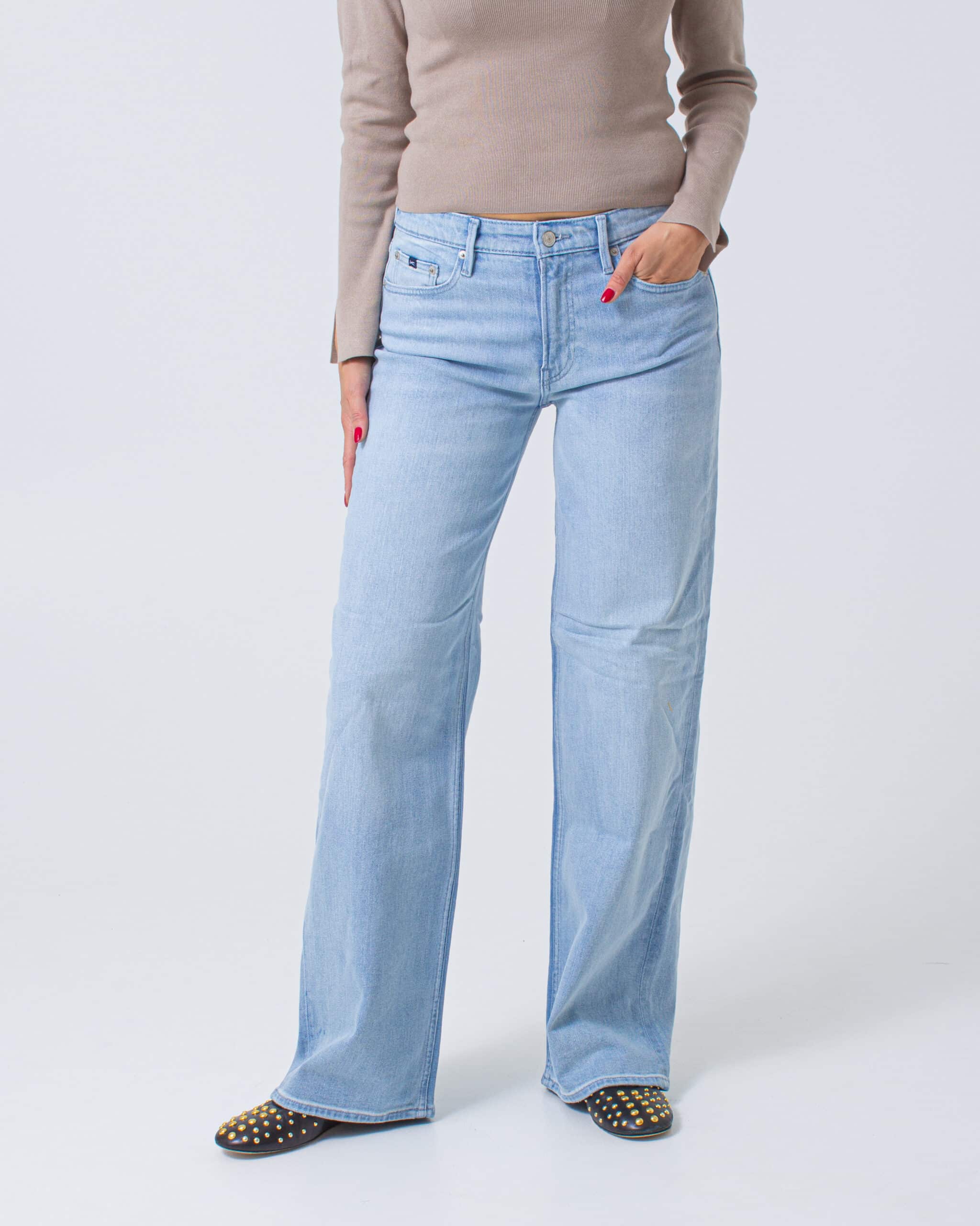 Light blue jeans worn by a person on a white background