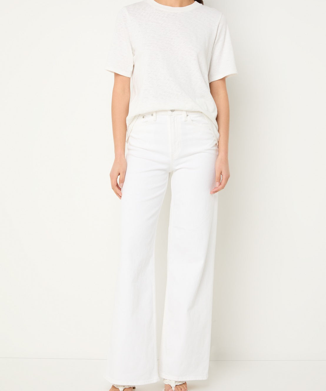Person wearing a white t-shirt and pants on a plain background