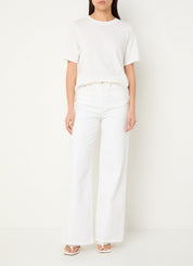 Person wearing a white t-shirt and pants on a plain background